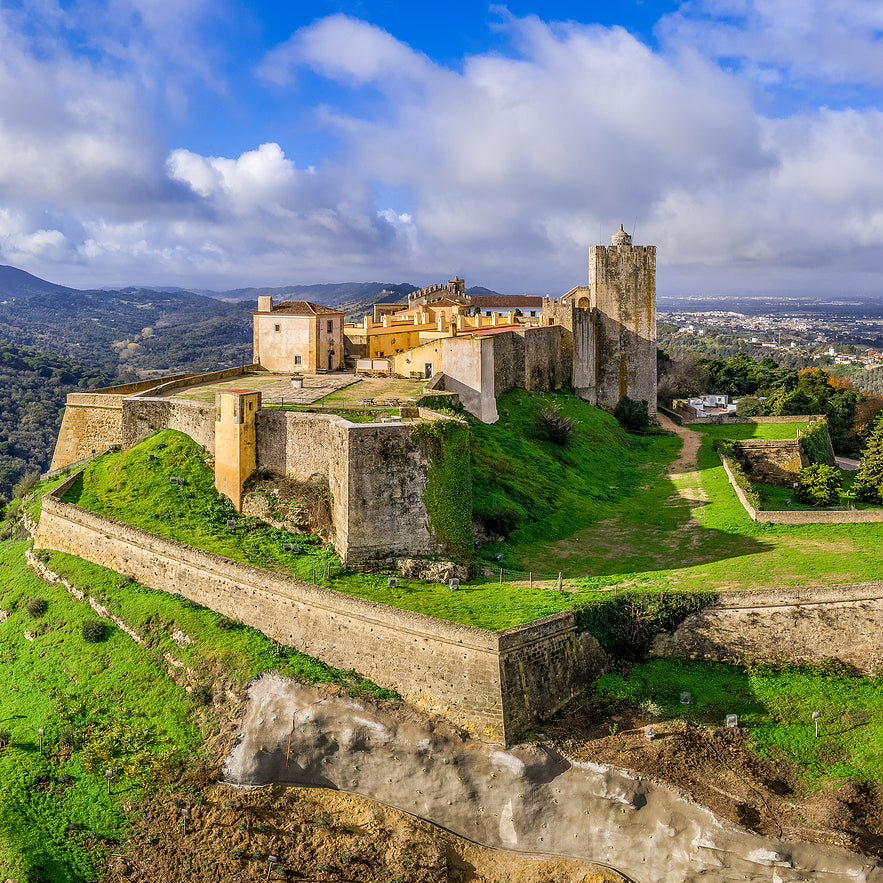 Ancient castle on a hill with green grass and blue sky